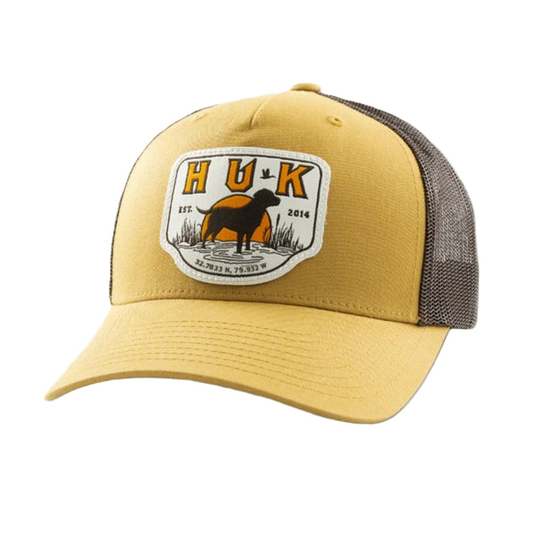 Yellow Huk Lab Patch Trucker Hat with a logo featuring a dog and Huk logo on a white background.