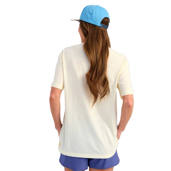 Woman wearing a Huk Fishing Trout Wranger t-shirt and cap on a white background.