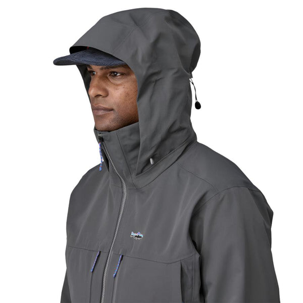 Person wearing a Patagonia Men's Swiftcurrent Wading Jacket in forge grey color showing hood details on a white background.