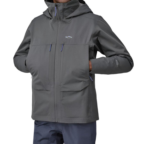 Person wearing a Patagonia Men's Swiftcurrent Wading Jacket in forge grey color showing pocket details on a white background.