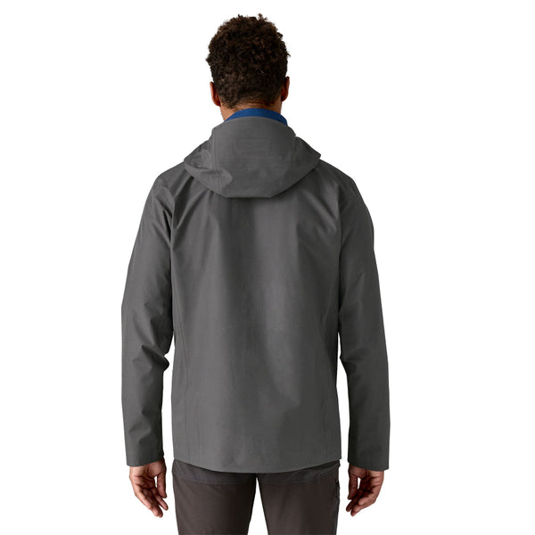 Man wearing the forge grey Patagonia Men's Triolet Alpine Jacket on a white background.