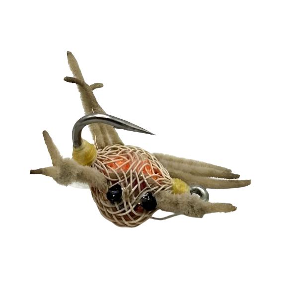 Saltwater Flexo Crab fly with tan flexo body, tan chenille legs and black eyes on a white background.