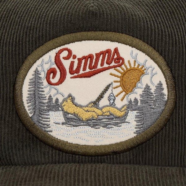 Embroidered patch with 'Simms' logo and nature scene on a brown background.