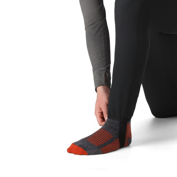 Person wearing the black Simms Men's Strata 330 Fleece Bottoms showing cuff detail on a white background.
