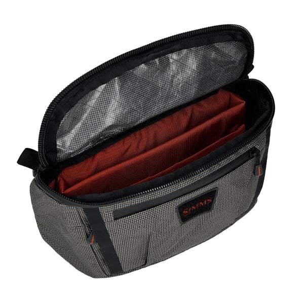 Black and gray Simms Scout Hip Pack bag with orange accents shown open from the top on a white background.