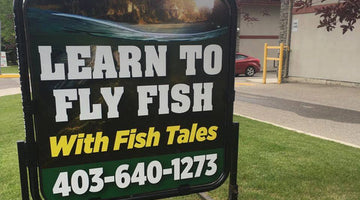 A Fish Tales level one fly fishing class sign outside that reads learn to fly fish with Fish Tales 403-640-1273.