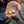 Hand holding four Airlock CenterLock Strike Indicators in various colors against a blurred natural background.