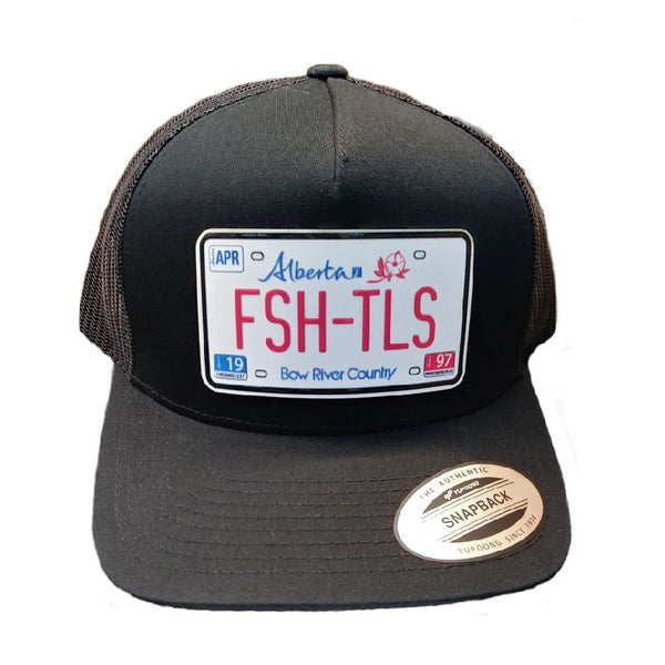 Black trucker cap with 'Fish Tales Fly Shop' Alberta license plate patch, on a white background.