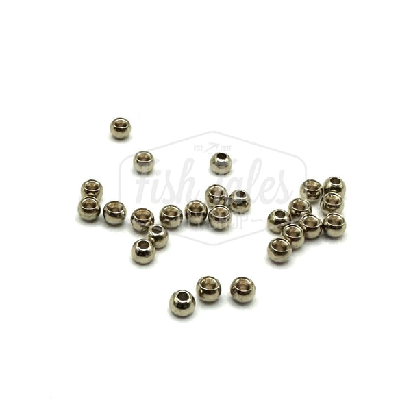 A collection of nickel color brass fly tying beads scattered on a white surface.