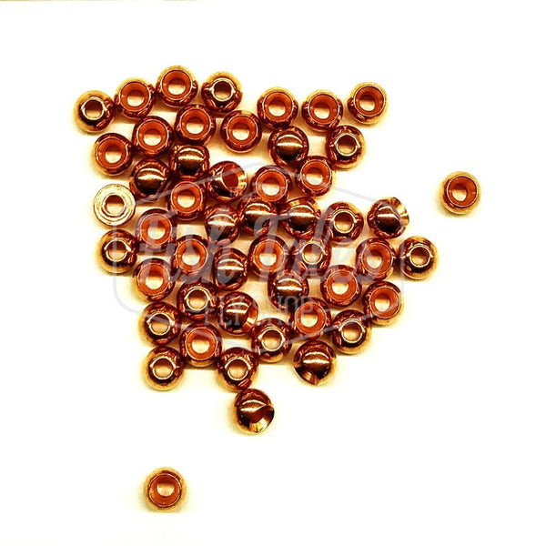 Several copper fly tying beads on a white background.