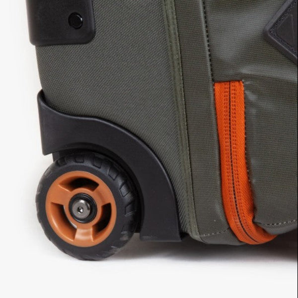 Close up of the wheels on the green Fishpond Stormshadow Rolling Duffel series on a white background.