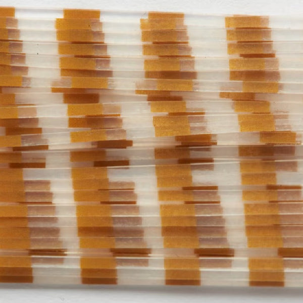 Close up of clear barred tan Fulling Mill Barred Legs for fly tying, on a white background.