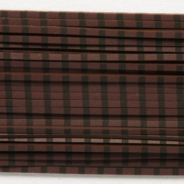 Close up of coffee barred black Fulling Mill Barred Legs for fly tying, on a white background.