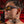 a man with tattoos wearing Goodr BFG Beelzebub's Bourbon Burpees Polarized Sunglasses on a red background.