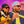 Two people wearing nautical themed clothing and a pair of navy-colored Goodr BFG Electric Beluga Boogaloo Polarized Sunglasses with brown gradient lenses on a sunset background.
