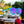Teal framed Goodr Circle G I Pickled These Myself Sunglasses with lilac lenses sitting on pickle jars with a blurred nature background.