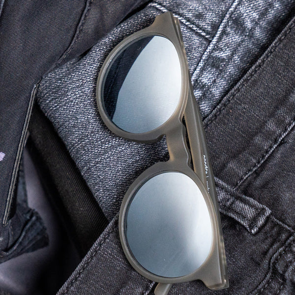 Goodr Circle G Sunglasses with reflective lenses on a dark fabric background.