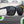 A pair of matte black Goodr LFG sunglasses on a level with a blurred background.