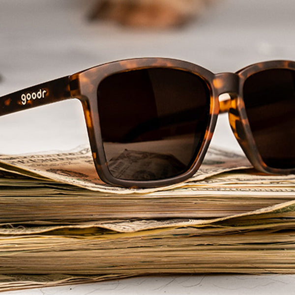 Goodr LFG Smaller is Baller Sunglasses on a stack of money.