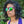 Person wearing Purple Goodr OG Gardening With a Kraken sunglasses with blue lenses standing outdoors with greenery in the background