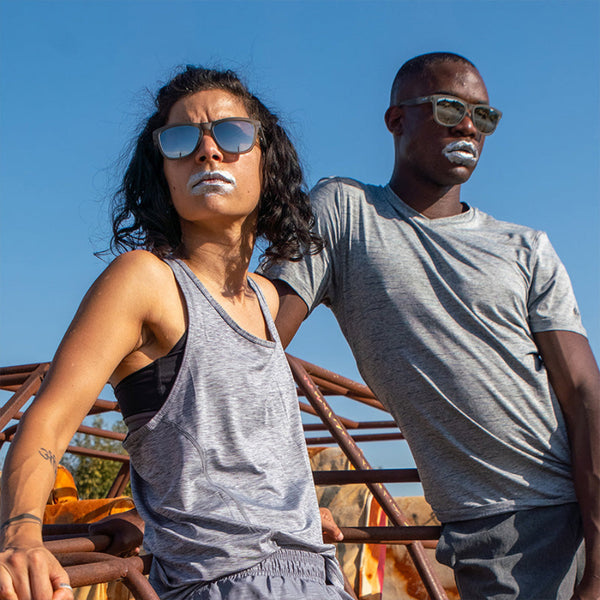Two people wearing Grey Goodr OG Going To Valhalla Witness sunglasses  with a clear blue sky background.