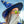 Person wearing a blue wizard hat with star patterns and Goodr OG Sunbathing With Wizards Sunglasses against a blurred natural background.