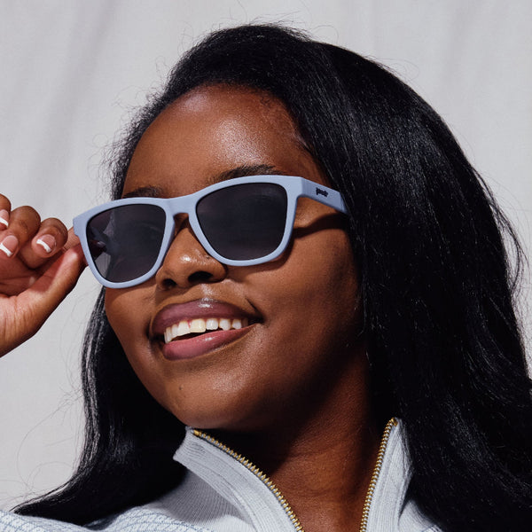 Woman wearing Goodr OG Zombie Skincare Routine sunglasses with a neutral background.