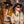 Two people in safari outfits with a gold mask and Goodr PHG sunglasses against a textured wall.