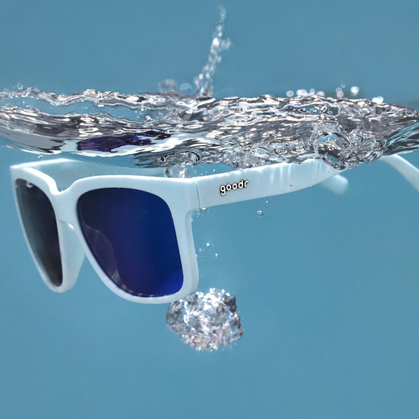 Light blue Goodr Tidal G sunglasses with blue lenses floating in clear water.