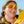 Person wearing Goodr Wrap G sunglasses and holding a bunch of yellow bananas against a blue sky background.