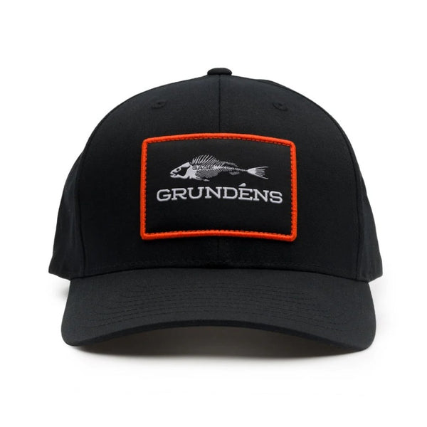 Front view of the Grundens Fish Bones Trucker Hat in black and featuring a logo patch with fish bones graphic, on a white background.
