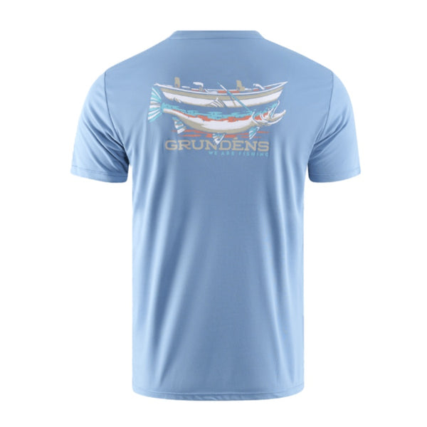 Light blue Grundens Men's Drift Boat Short Sleeved Tech T-Shirt with a boat graphic and branding on the back against a white background.