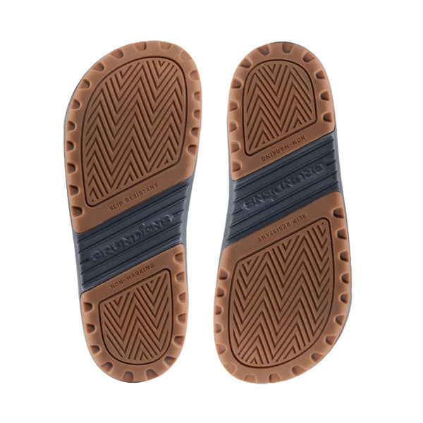 Brown sole of the Grundens Men's Fish-On Slip-On shoe with a zigzag pattern, on a white background.
