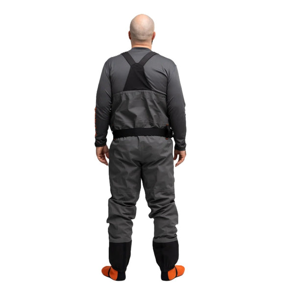 Person shown from the back wearing the Grundéns Men's Vector Stockingfoot Wader featuring anchor grey material with black belt and gravel guards and orange neoprene booties, against a white background.