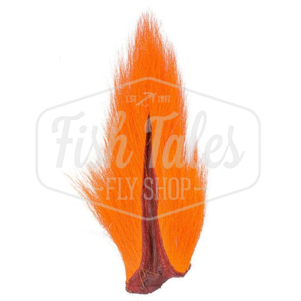 An orange dyed Hook and Hackle Whole Bucktail for fly tying shown from the underside, on a white background with the Fish Tales logo watermark.