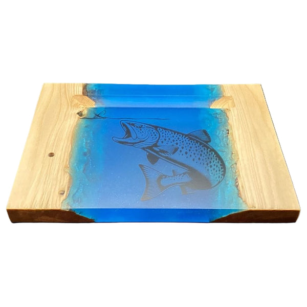 Wooden Hooked By Fishing River Pour Fly Tying Base with blue resin and charcoal black brown trout carving on a white background.