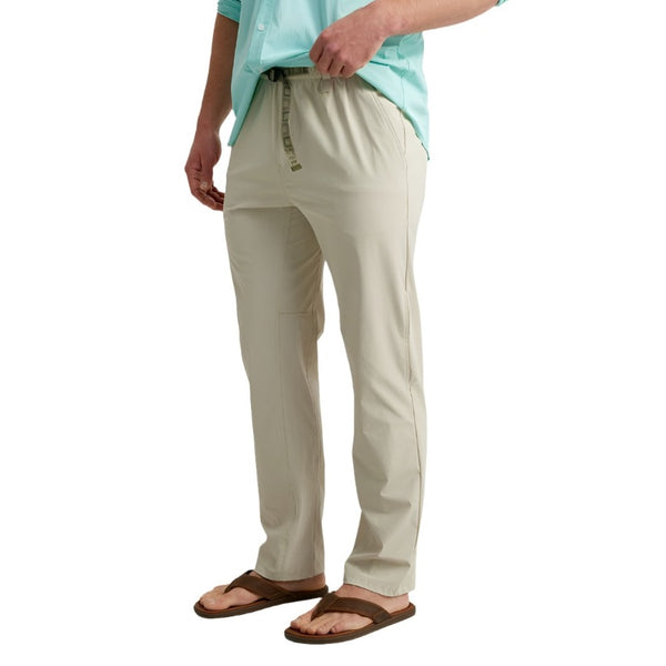 front view of a man wearing khaki huk fishing men's creekbed wet wading pants on a white background