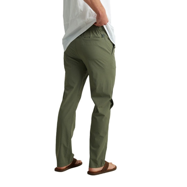 back view of a man wearing moss green huk fishing men's creekbed wet wading pants on a white background