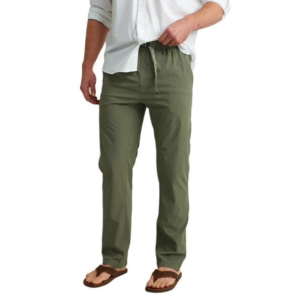 front view of a man wearing moss green huk fishing men's creekbed wet wading pants on a white background