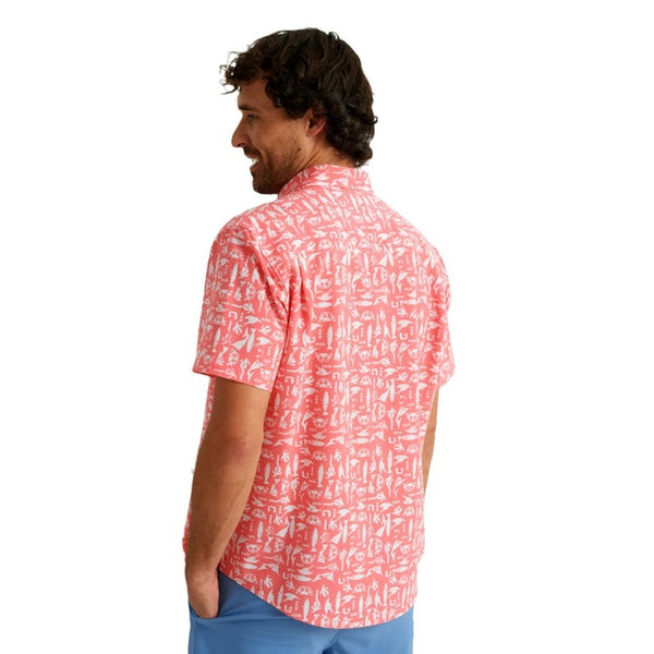 back view of a man wearing a batiki print sunwashed red color huk fishing men's kona button down short sleeve shirt on a white background
