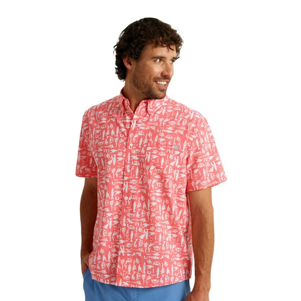 front view of a man wearing a batiki print sunwashed red color huk fishing men's kona button down short sleeve shirt on a white background