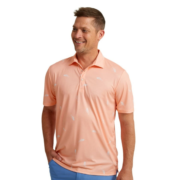 front view of a man wearing a huk fishing mens pursuit polo in fresh bones peach nectar on a white background