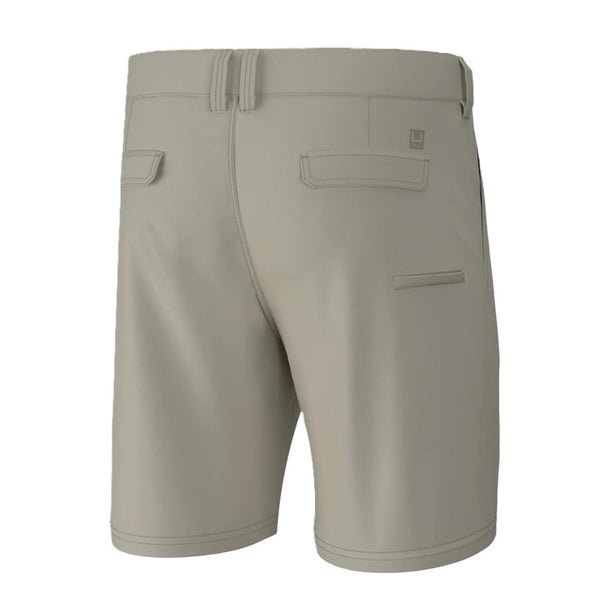 back view of a pair of khaki huk fishing mens pursuit 8.5 inch shorts on a white background