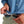 a woman cleaning aviator sunglasses with the built in lens cloth of the light blue huk fishing womens tide point button down long sleeve shirt she is wearing on a white background