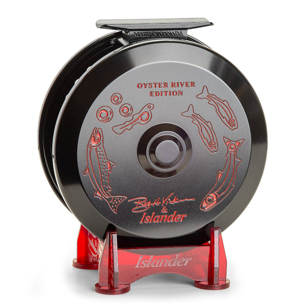 The Islander TR3 Trolling Reel - Oyster River Edition in black with red engraved artwork on a stand, against a white background.