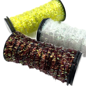 three colors of kreinik micro ice chenille spooled for fly tying on white background