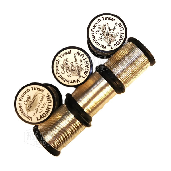 several spools of silver lagartun oval metal fly tying tinsel on a white background 