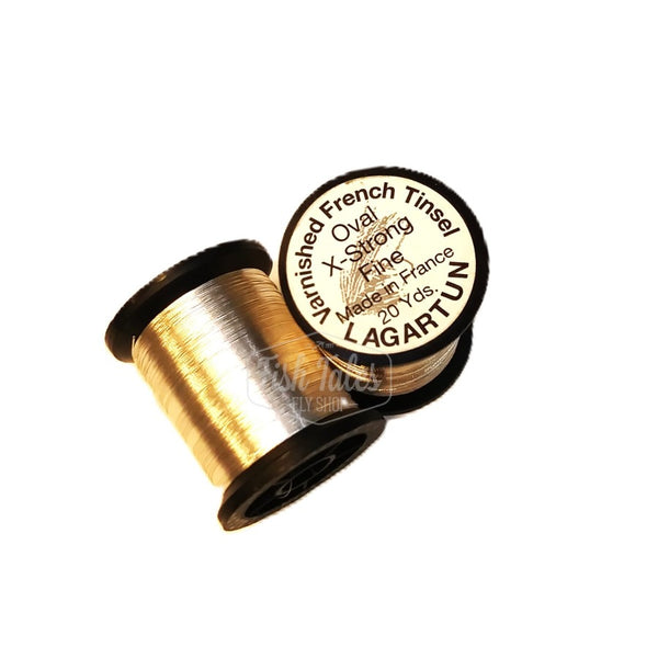 several spools of silver lagartun oval metal fly tying tinsel on a white background 