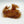A bundle of brown mohair dubbing on a white background, used for crafting fishing flies.