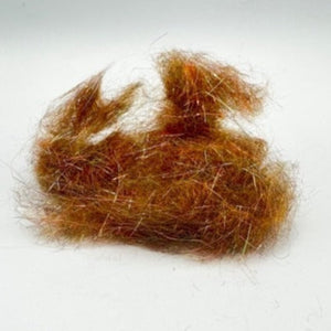 A bundle of brown mohair dubbing on a white background, used for crafting fishing flies.